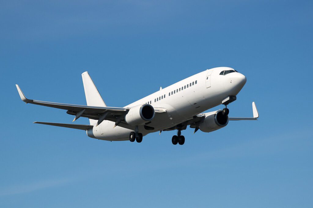 Vue rapprochée des ailes d'un avion en vol sur fond de ciel dégagé.
