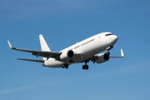 Vue rapprochée des ailes d'un avion en vol sur fond de ciel dégagé.